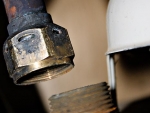04 Holes burned in water heater fitting. Photo Jake Jakabosky